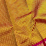 Sumangala - Golden mustard and rani pink handwoven Kanchipuram silk saree with zari checks and border