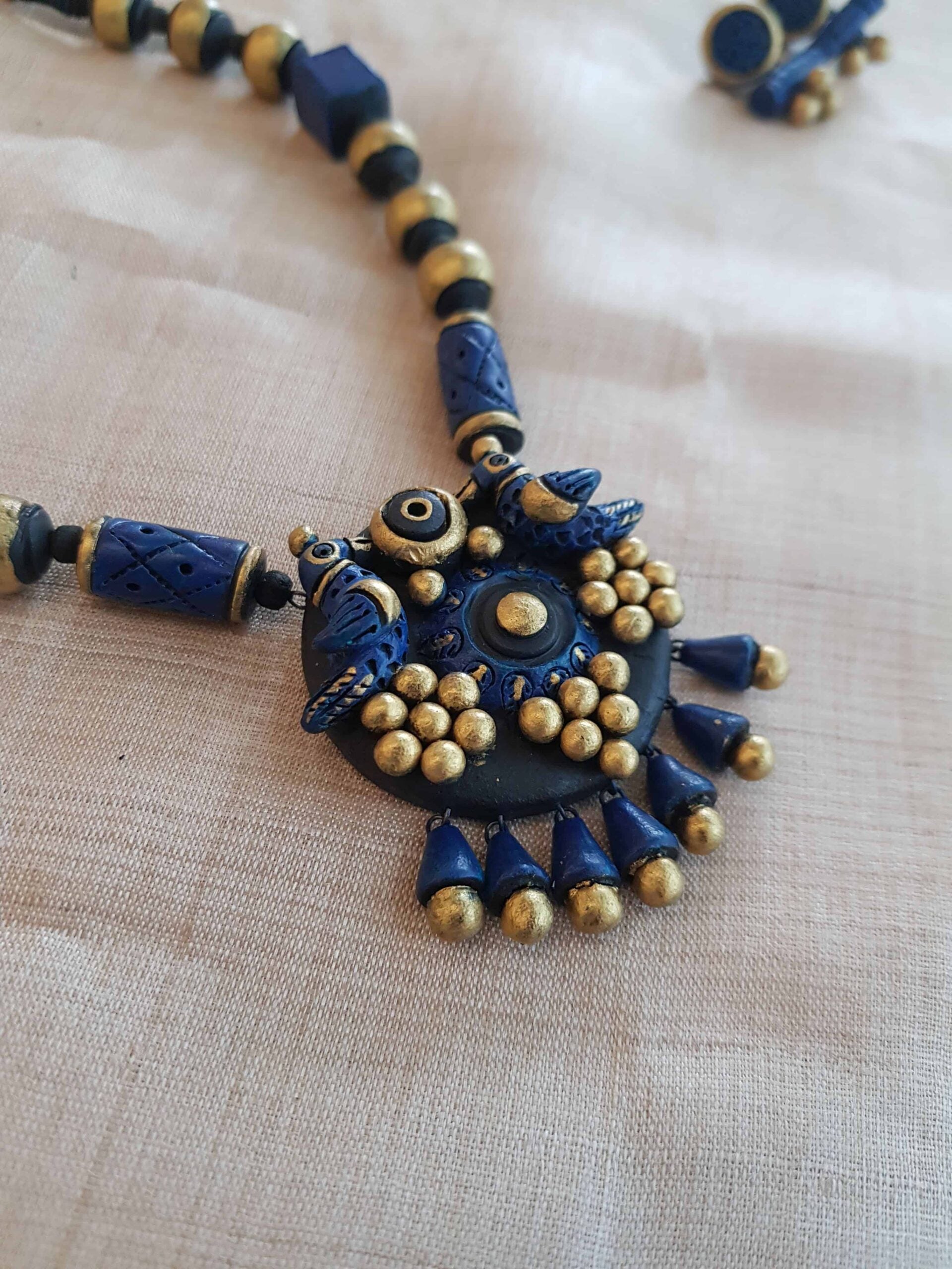 Blue-and-gold-geometric-designed-handmade-terracotta-necklace-with-birds-pendant-1-1.jpg